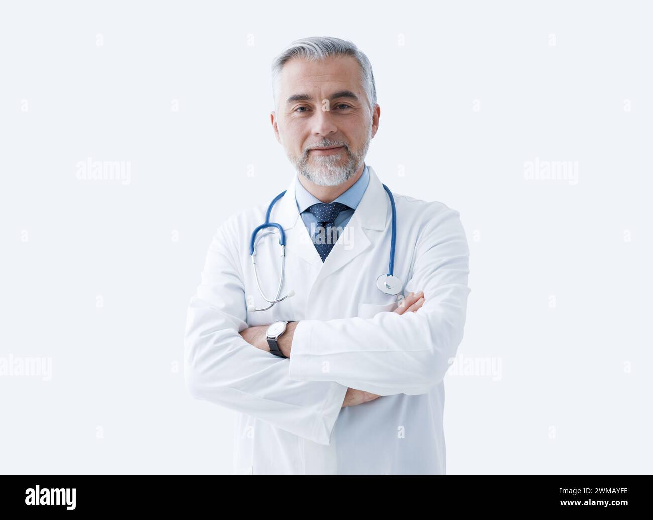 Selbstbewusster Arzt posiert mit überkreuzten Armen und lächelnd, Gesundheitswesen und Medizin Konzept Stockfoto