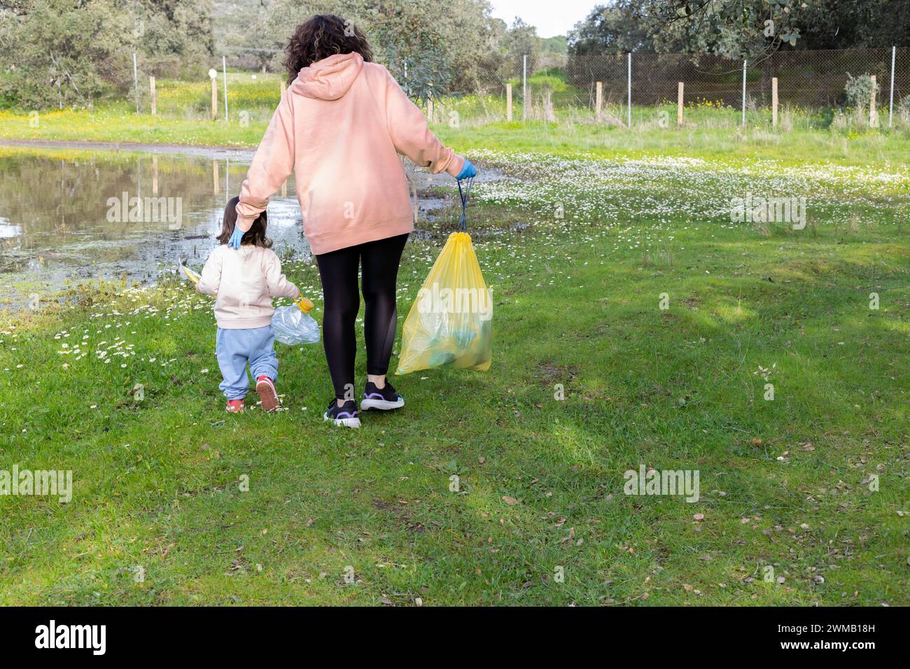 Mutter und Tochter an einem Frühlingstag sammeln Plastik an einem Freiwilligentag. Konzept Umwelt, Recycling, Klimawandel Stockfoto