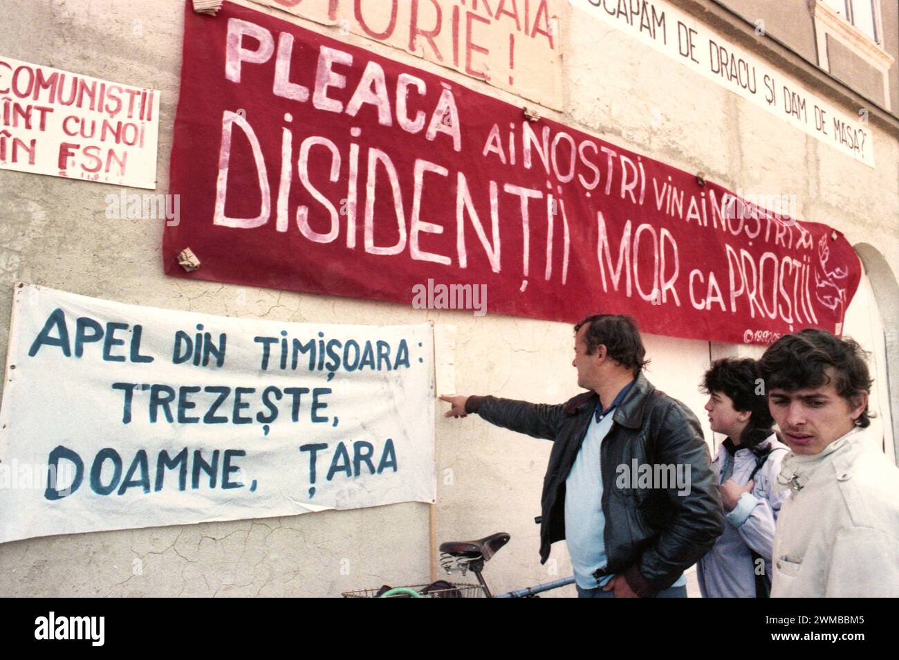 Brasov, Rumänien, April 1990. Nach der antikommunistischen Revolution von 1989 brachen im ganzen Land Proteste gegen die ehemaligen kommunistischen Beamten aus, die sofort die Macht ergriffen hatten. Auf dem zentralen Platz von Brasov lesen die Menschen Plakate und Transparente, die die neue Partei an der Macht, F.S.N., verurteilten Stockfoto