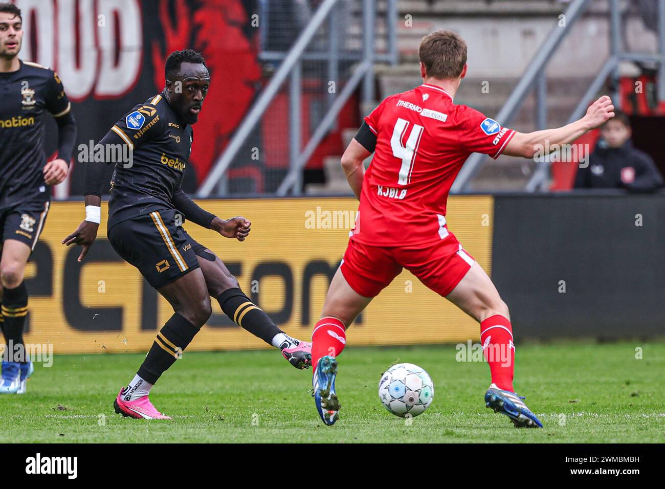 Enschede, Niederlande. Februar 2024. ENSCHEDE, NIEDERLANDE - 25. FEBRUAR: Bobby Adekanye von Go Ahead Eagles macht einen Pass, Mathias Kjolo vom FC Twente versucht, ihn während des niederländischen Eredivisie-Spiels zwischen dem FC Twente und Go Ahead Eagles am 25. Februar 2024 in Grolsch Veste in Enschede zu stoppen. (Foto von Henny Meyerink/BSR Agency) Credit: BSR Agency/Alamy Live News Stockfoto