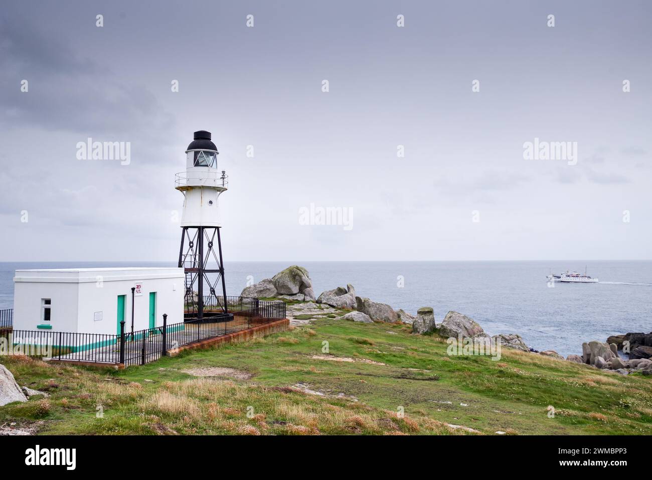 Peninnis Head Lighthouse, Scillonian Ferry mit Abfahrt von St. Mary's im Hintergrund (Scilly-Inseln, Großbritannien) Stockfoto