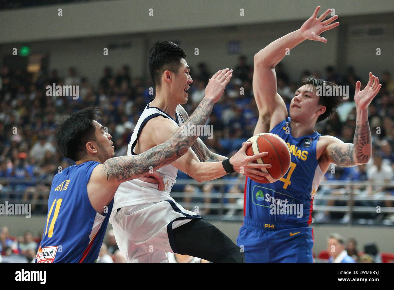 Pasig City, Metro Manila, Philippinen. Februar 2024. Kai Sotto (blau, 11) und Dwight Ramos (blau, 24) von den Philippinen leiten einen Pass von Cheng Liu (weiß, 5) in Chinesisch-Taipeh ab. (Kreditbild: © Dennis Jerome Acosta/Pacific Press via ZUMA Press Wire) NUR REDAKTIONELLE VERWENDUNG! Nicht für kommerzielle ZWECKE! Stockfoto