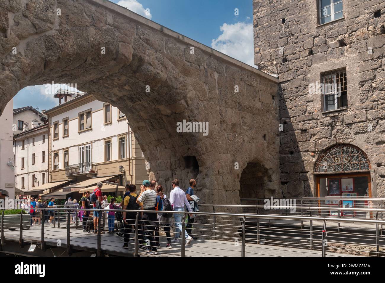 Touristen überqueren das Pretoria-Tor (25 v. Chr.), das römische Stadttor, das von zwei Bögen gebildet wird, die einen Paradeplatz umschließen, Aosta, Aosta-Tal, Italien Stockfoto