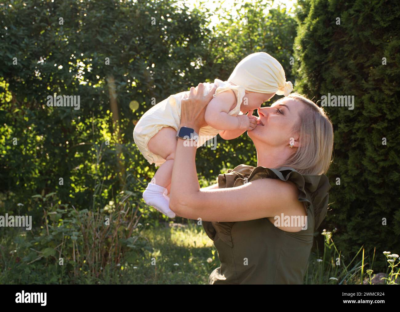 Mutter wirft ihr Baby in die Arme und lacht Stockfoto