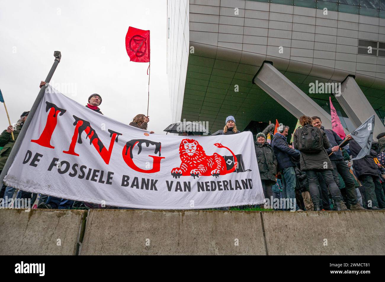 Amsterdam, Niederlande. Februar 2024. Aktivist der Extinction Rebellion steht gegenüber der Autobahn A10 mit einem Banner, das ihre Meinung zum Ausdruck bringt, während der Blockade der Autobahn. Extinction Rebellion, eine Blockade auf der Autobahn A10 in Amsterdam; 15 Minuten nachdem die ersten Demonstranten auf der Autobahn gelaufen waren, begann die Polizei mit Verhaftungen. Insgesamt wurden 326 Verhaftungen vorgenommen und 31 blieben in Haft. Die restlichen 295 wurden per Bus nach Amsterdam Noord transportiert und freigelassen. Kurz vor dem Polizeieinsatz wurde der Aktivist gewarnt, dass du Schlagstöcke und Pfefferspray wärst Stockfoto