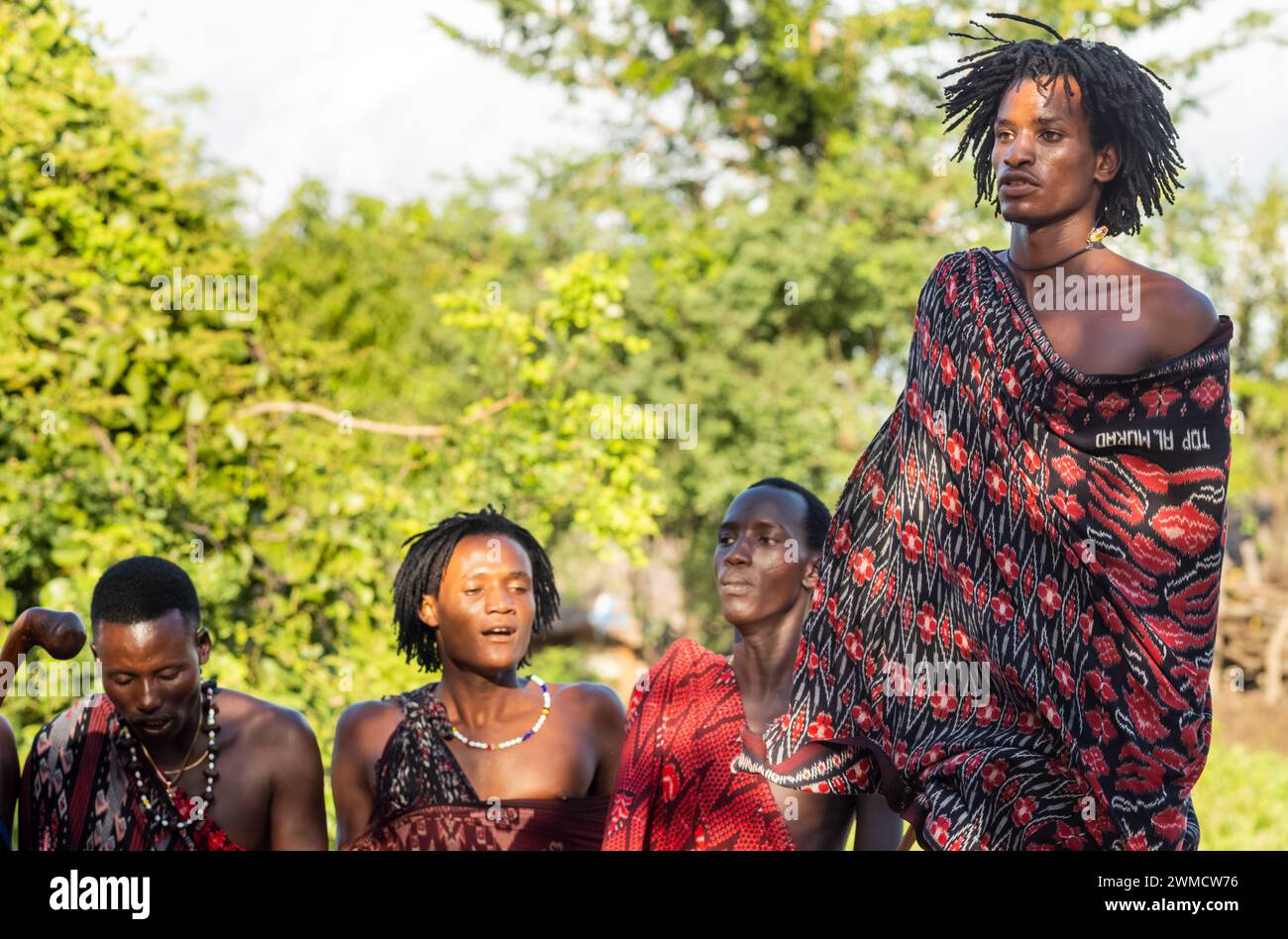 Maasai-Krieger singt und führt den traditionellen Springtanz in seinem Dorf in Mikumi, Tansania, auf Stockfoto