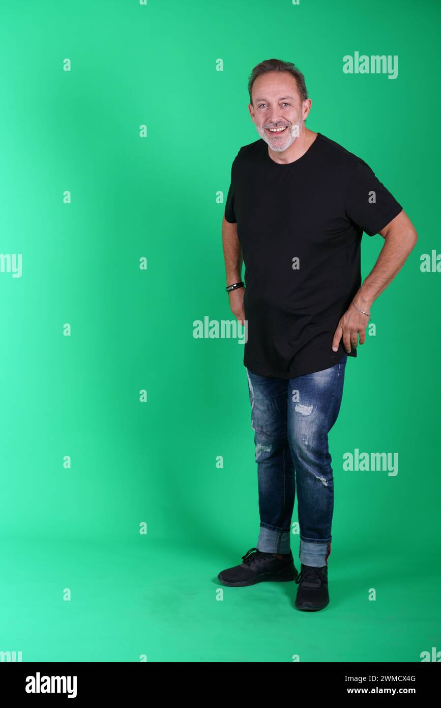 Echte Menschen, Mann in seinen 50ern, der lässige Kleidung trägt, sich auf dem grünen Bildschirm des Studios posiert, eine Vielzahl von Emotionen und Körperpositionen, voller Körper und Stockfoto
