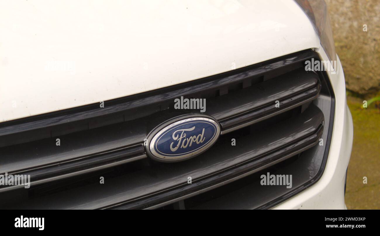 Dublin, Irland - 25. Februar 2024: Nahaufnahme eines dunkelblauen Ford-Logos auf der Vorderseite eines weißen Autos. Stockfoto Dublin, Irland - 25. Februar 2024: Nahaufnahme eines dunkelblauen Ford-Logos auf der Vorderseite eines weißen Autos. Stockfoto