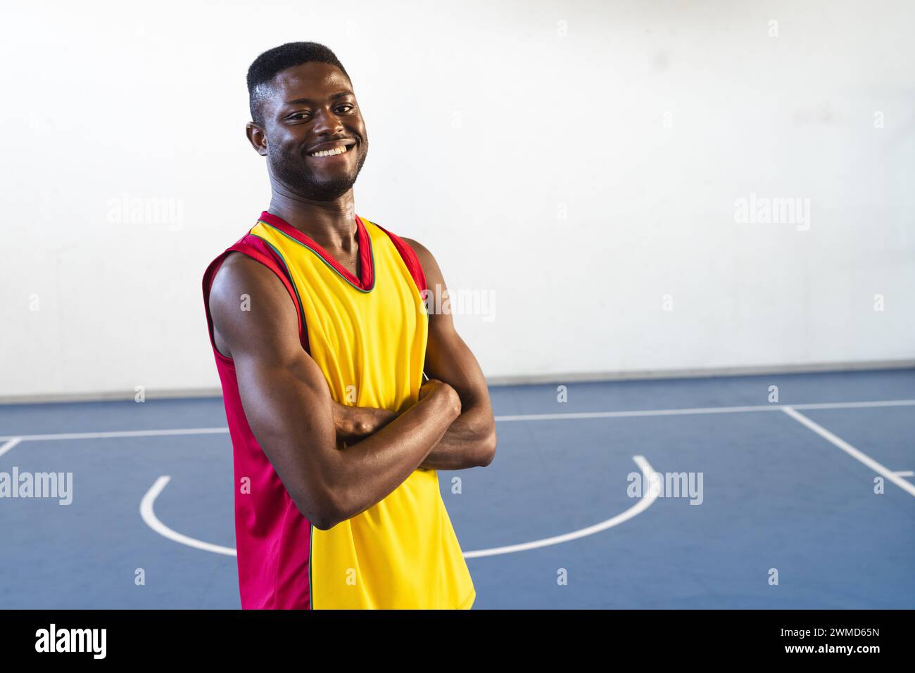 Ein selbstbewusster Afroamerikaner steht auf einem Basketballfeld Stockfoto