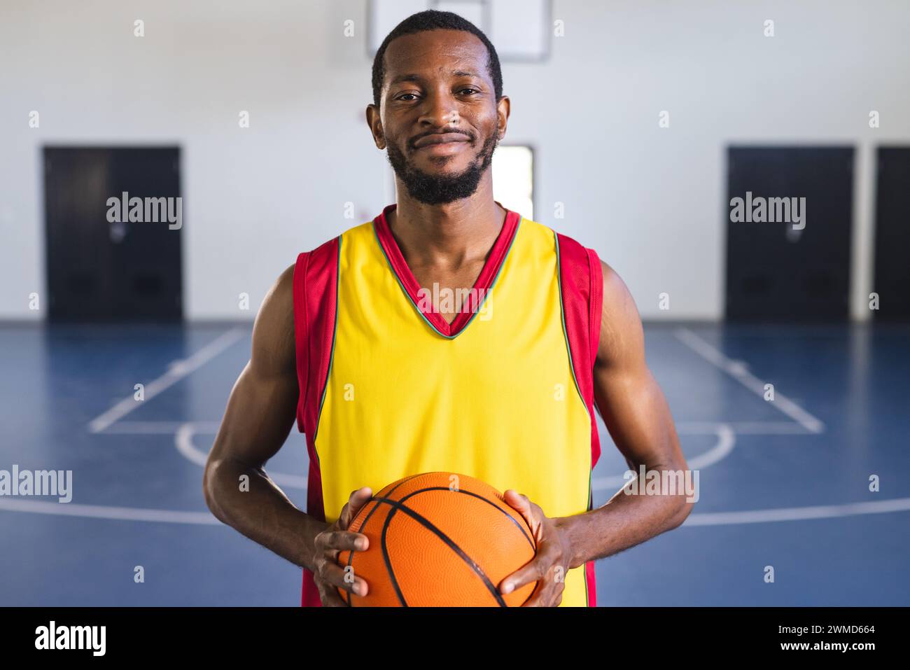 Afroamerikaner hält Basketball in einem Fitnessstudio Stockfoto