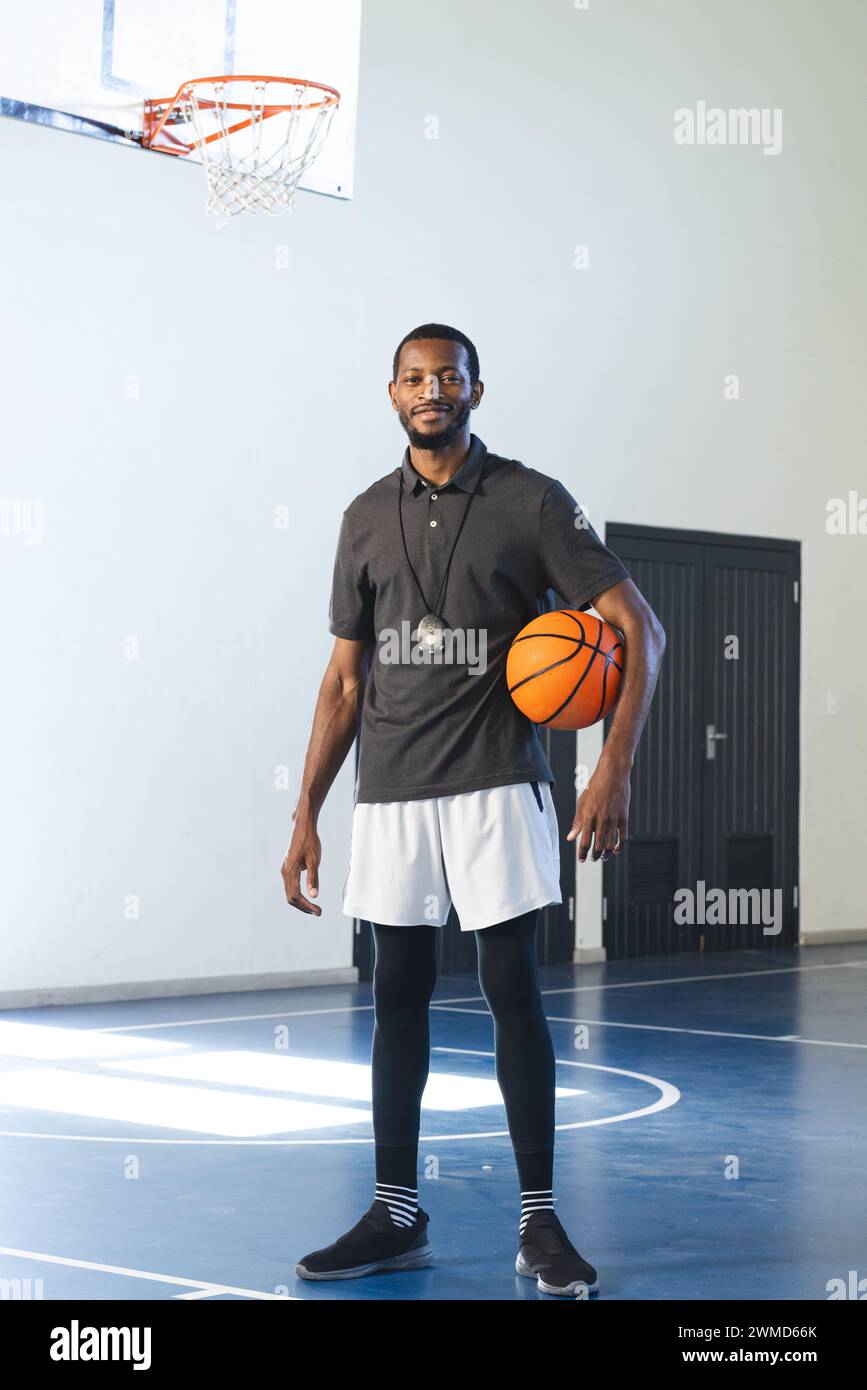 Afroamerikaner steht selbstbewusst auf einem Basketballfeld Stockfoto