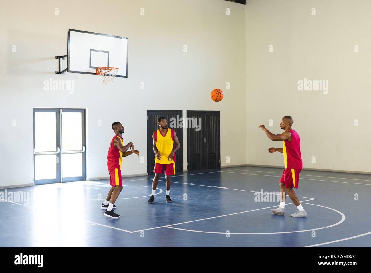 Drei Afroamerikaner spielen Basketball in der Halle Stockfoto