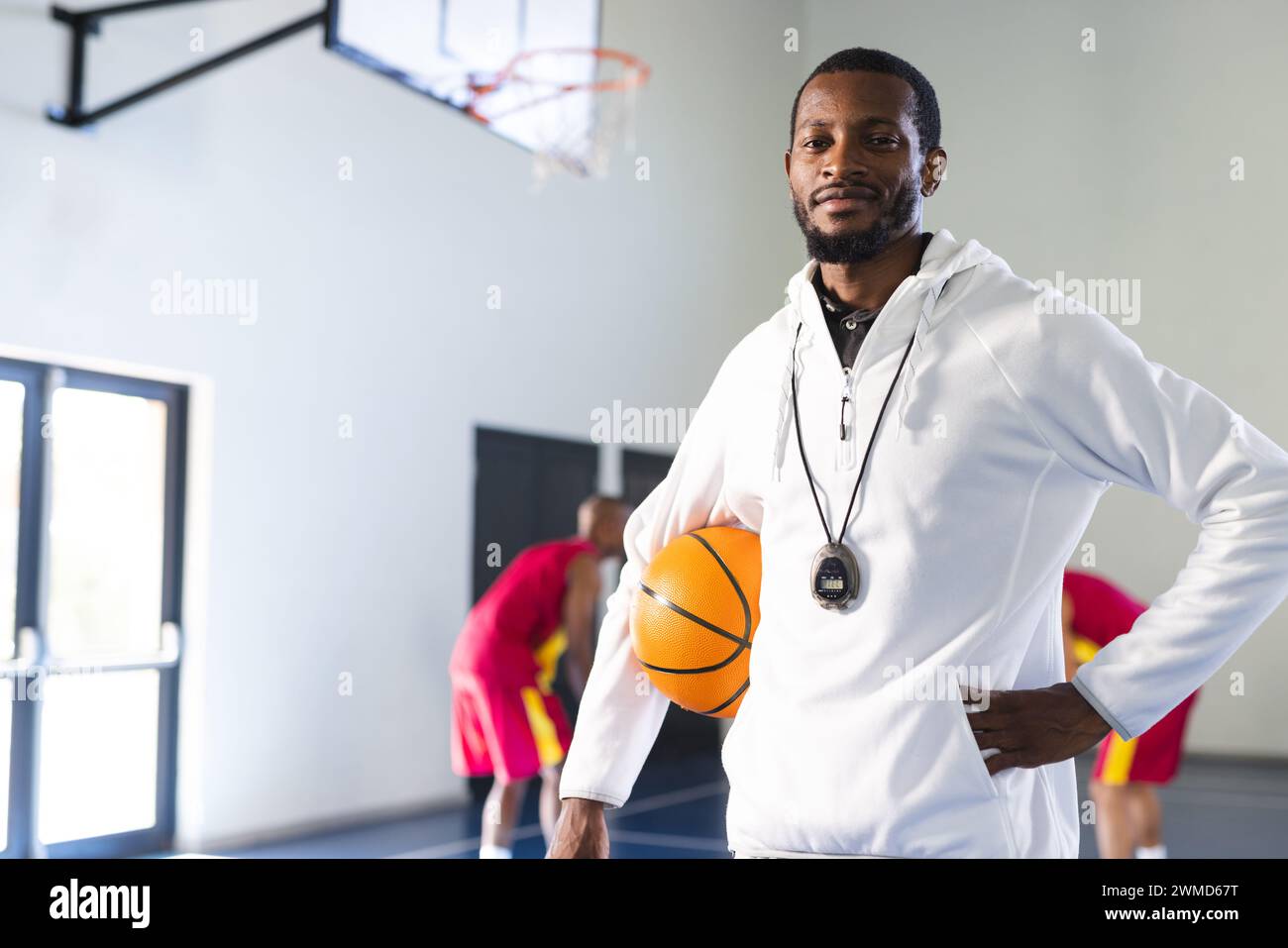 Der afroamerikanische Trainer steht selbstbewusst in einem Fitnessstudio mit Kopierraum Stockfoto