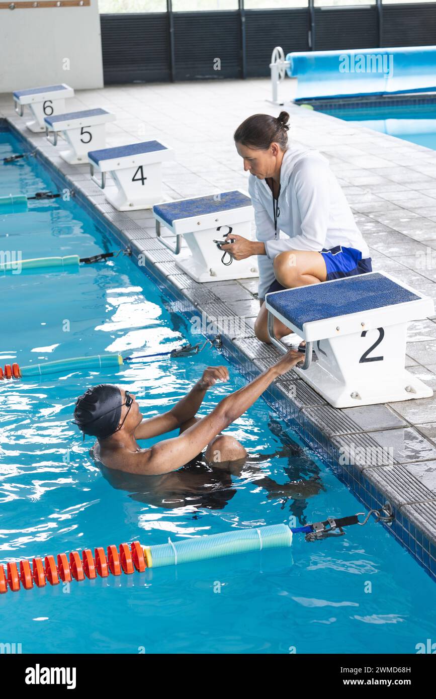 Schwimmtrainer gibt dem Sportler am Pool Feedback Stockfoto