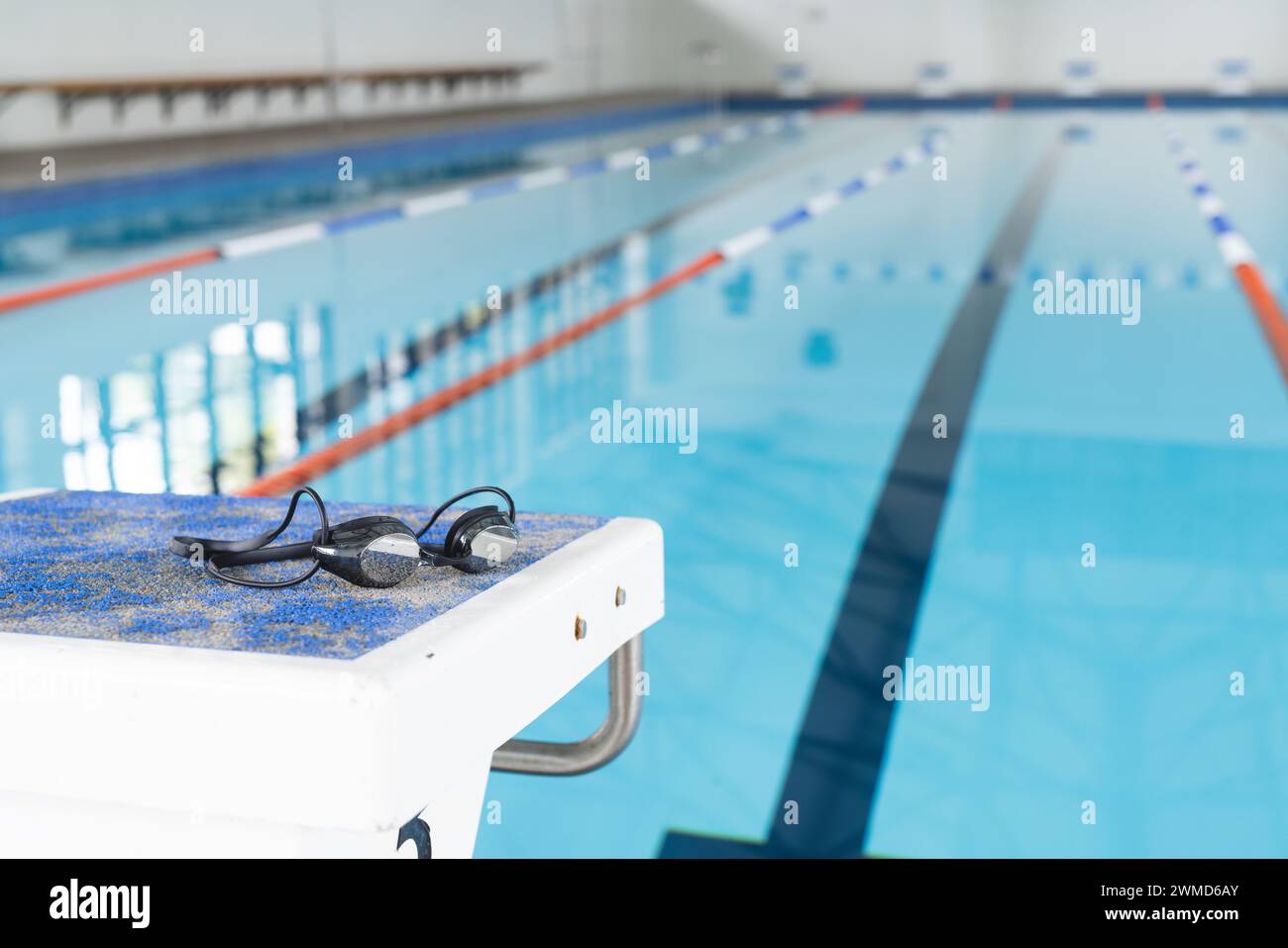 Schwimmbrillen ruhen sich am Rand eines Pools in einer Inneneinrichtung aus Stockfoto
