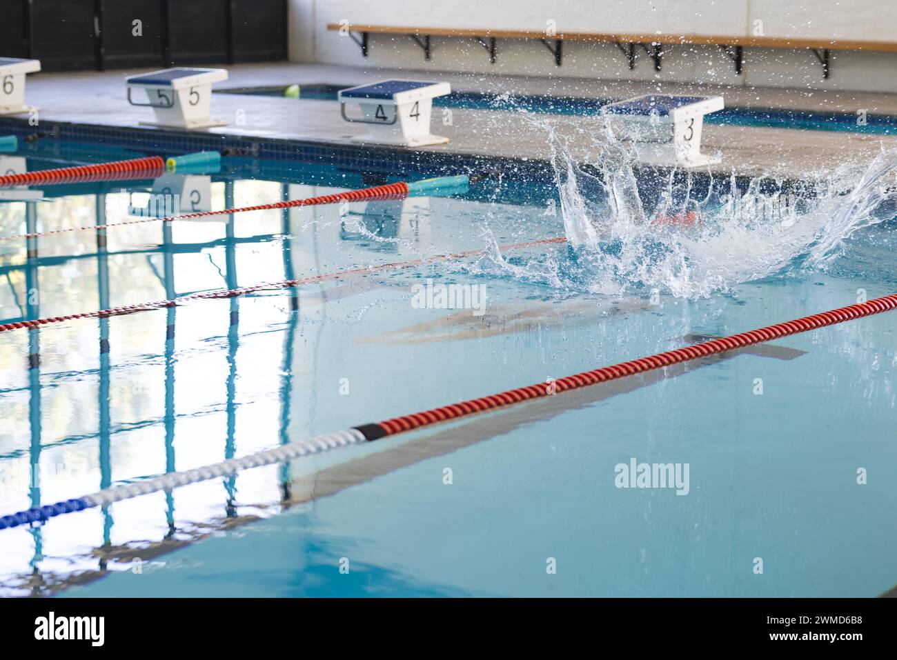 Ein Schwimmer taucht bei einem Wettkampf in einen Pool mit Platz für Kopien Stockfoto