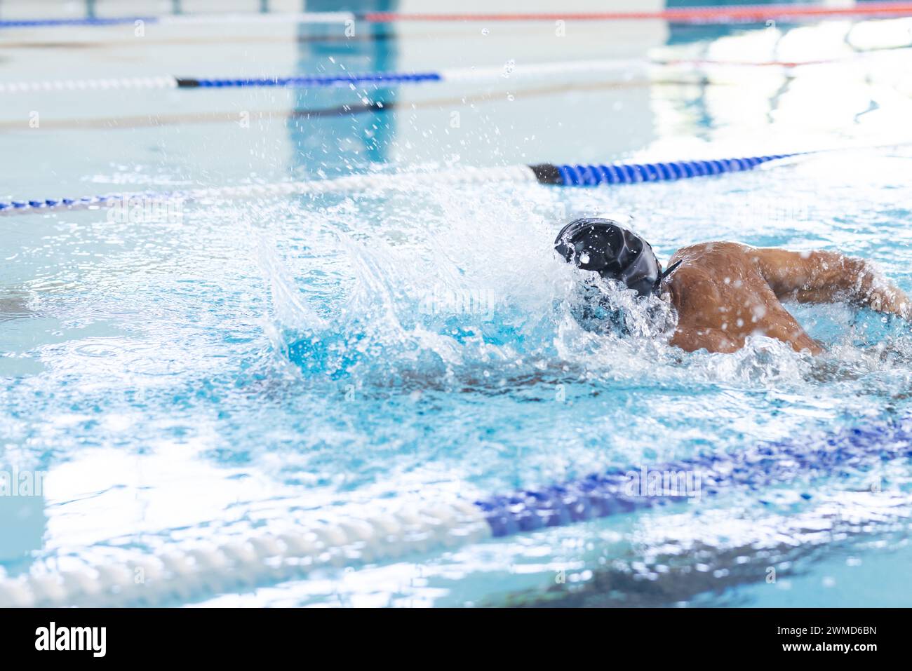 Ein junger männlicher Sportler schwimmt in einem Hallenbad Stockfoto