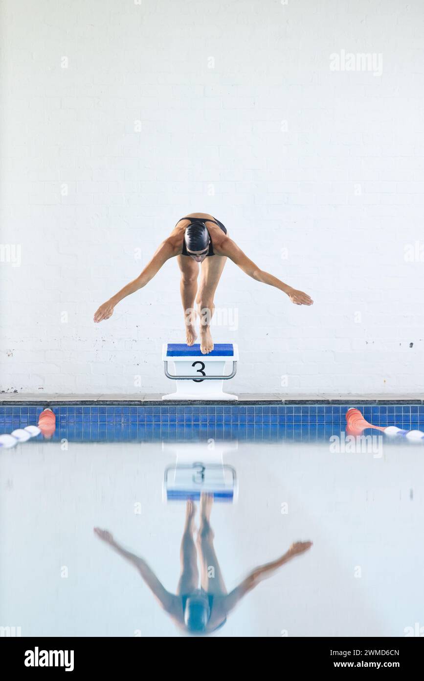 Der Sportler taucht in ein Schwimmbad mit Kopierraum ein Stockfoto