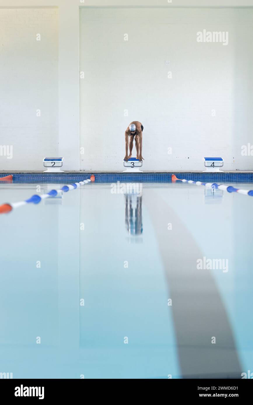 Ein Schwimmer bereitet sich auf das Tauchen in einem Hallenbad vor Stockfoto