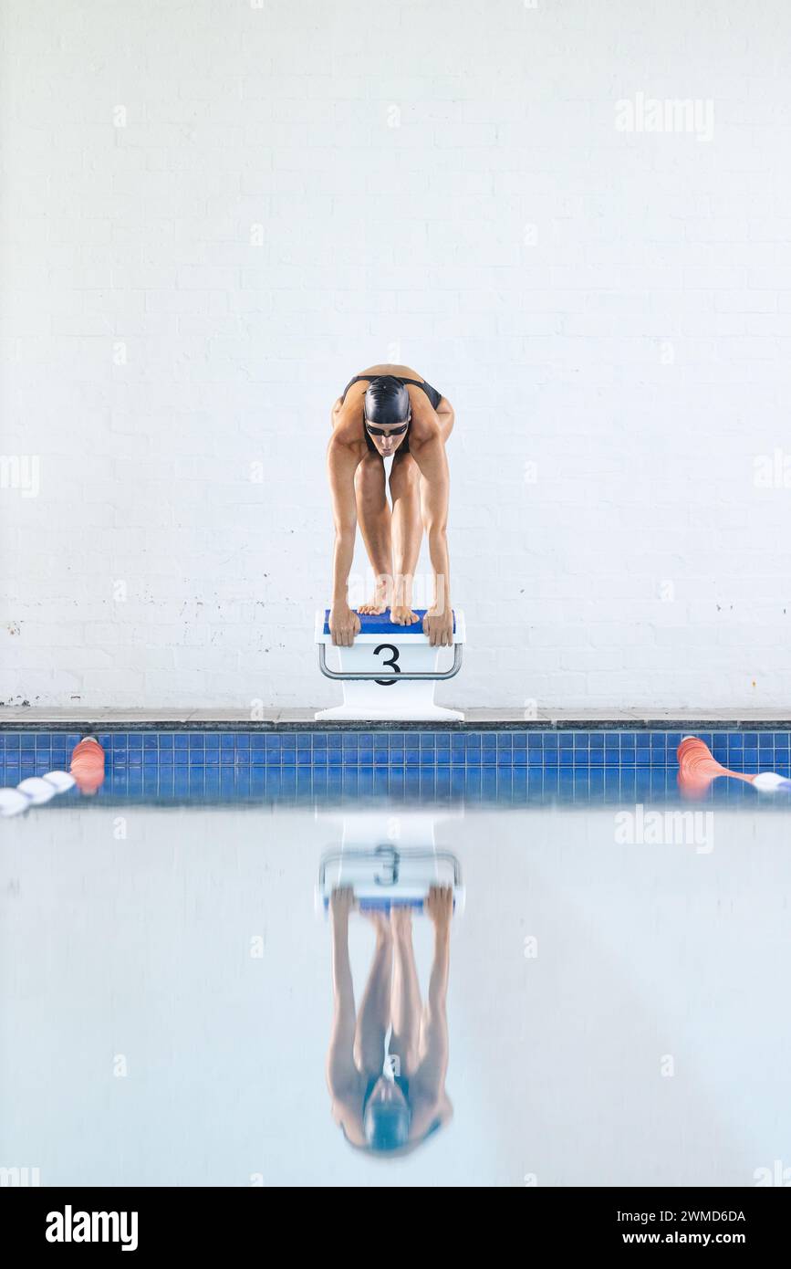 Ein Schwimmer bereitet sich darauf vor, bei einer Wettkampfveranstaltung in den Pool zu tauchen Stockfoto