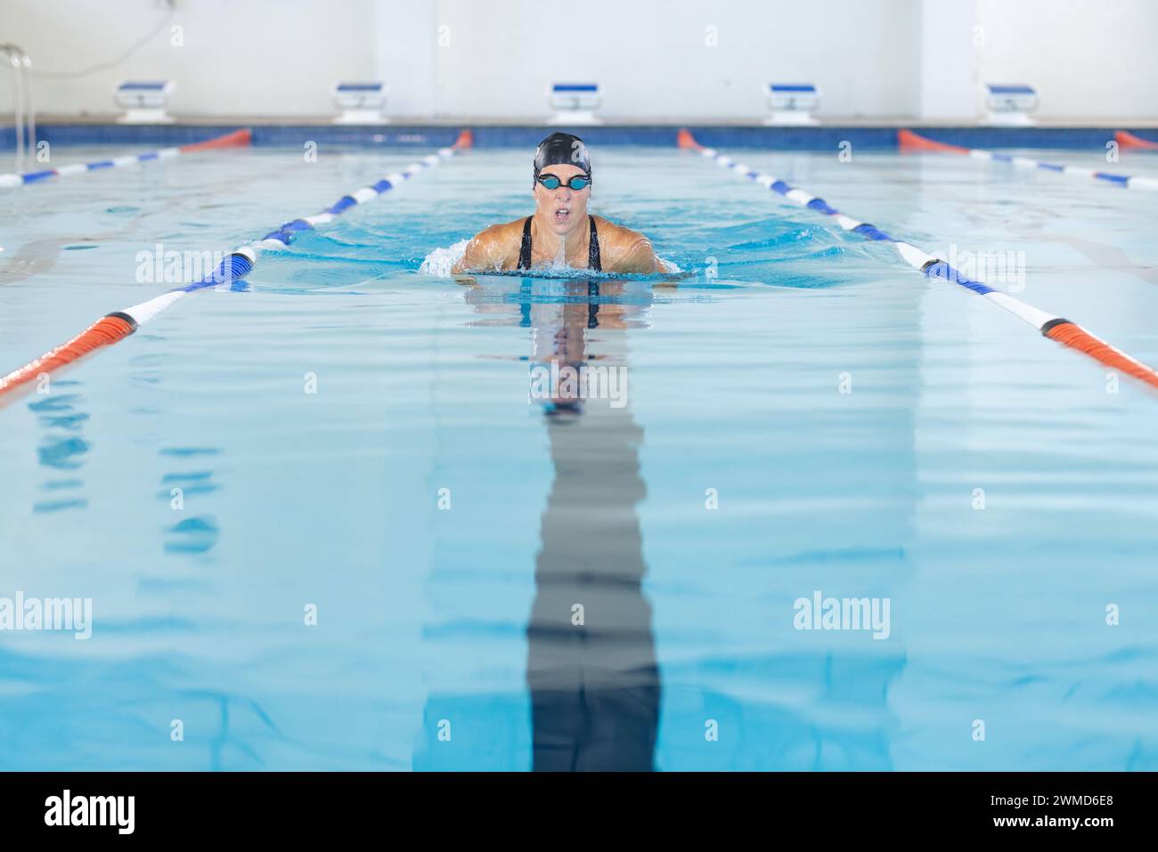 Weiße Sportlerin schwimmt in einem Pool in einem Sportzentrum Stockfoto