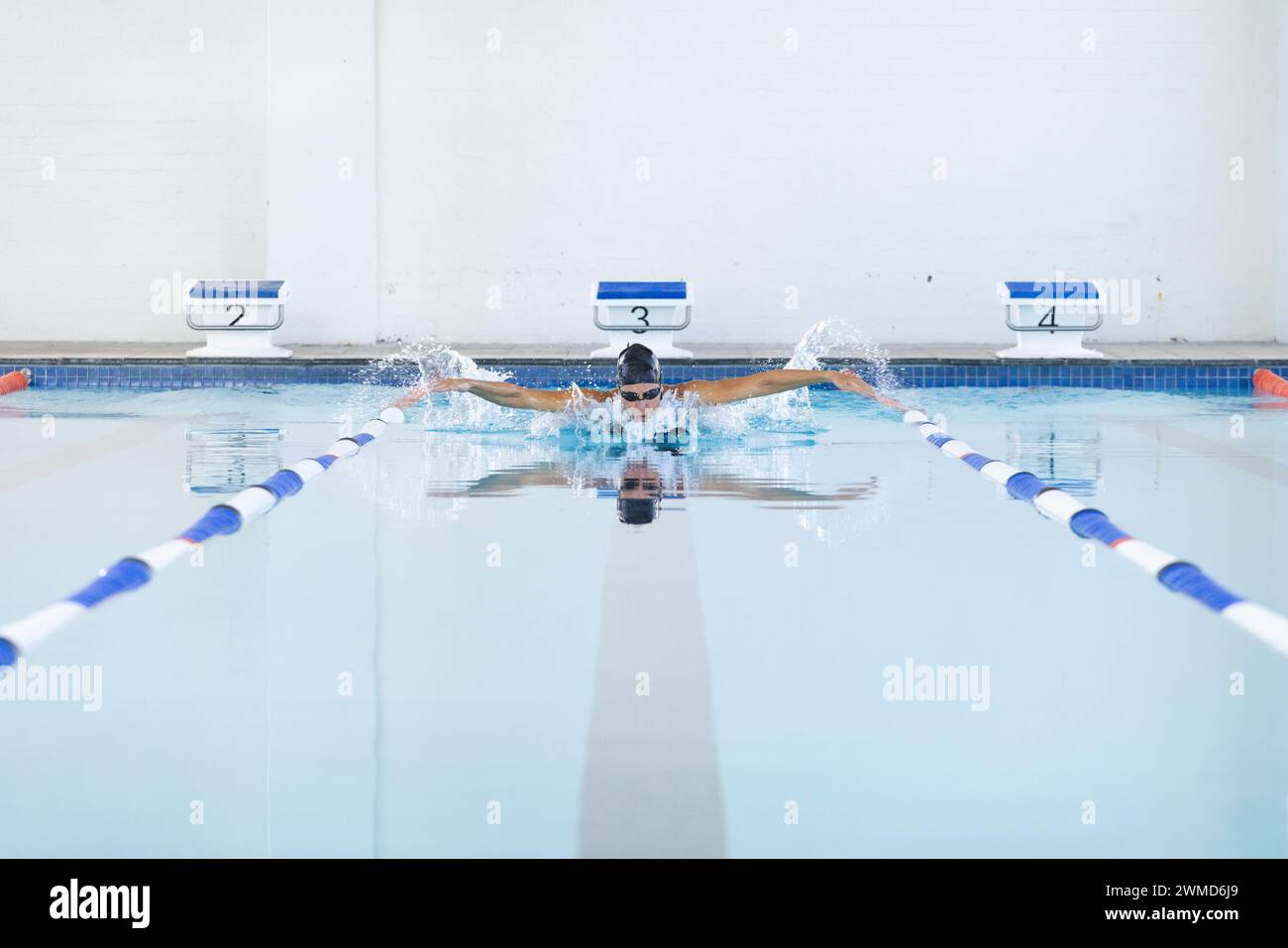 Die weibliche weibliche Sportlerin nimmt ein erfrischendes Bad in einem Hallenbad Stockfoto