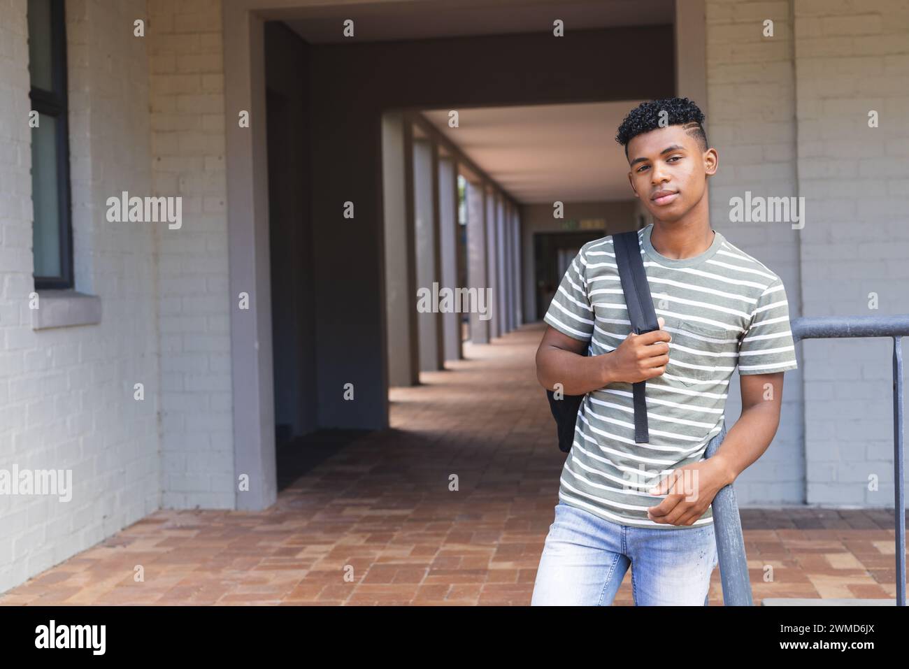 Teenager-Biracial-Junge steht selbstbewusst in der High School, mit Kopierraum Stockfoto