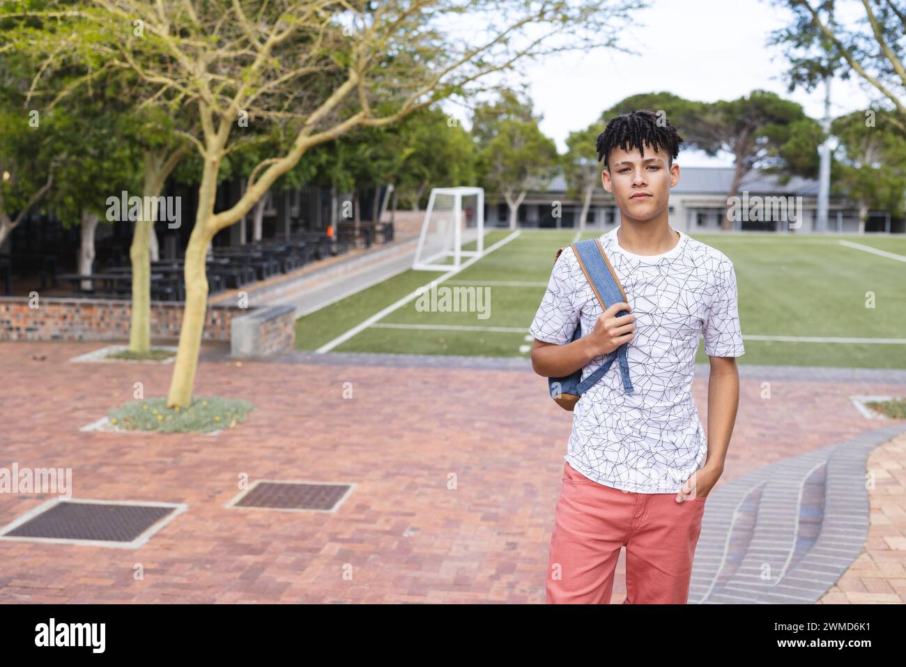 Teenager-Biracial-Junge steht selbstbewusst in der High School, mit Kopierraum Stockfoto