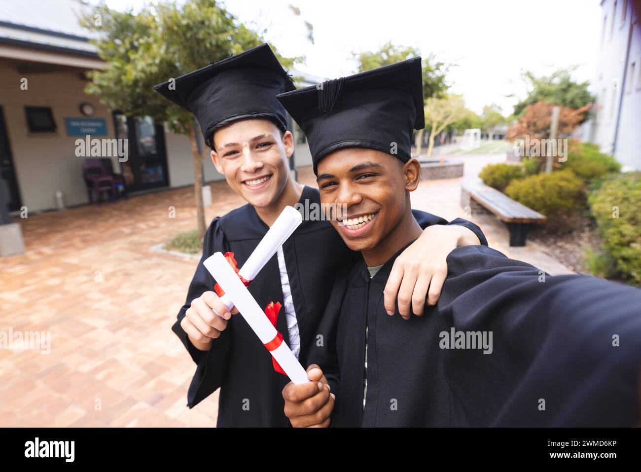 Zwei Teenager-Biracial-Jungs feiern den Abschluss im Freien Stockfoto