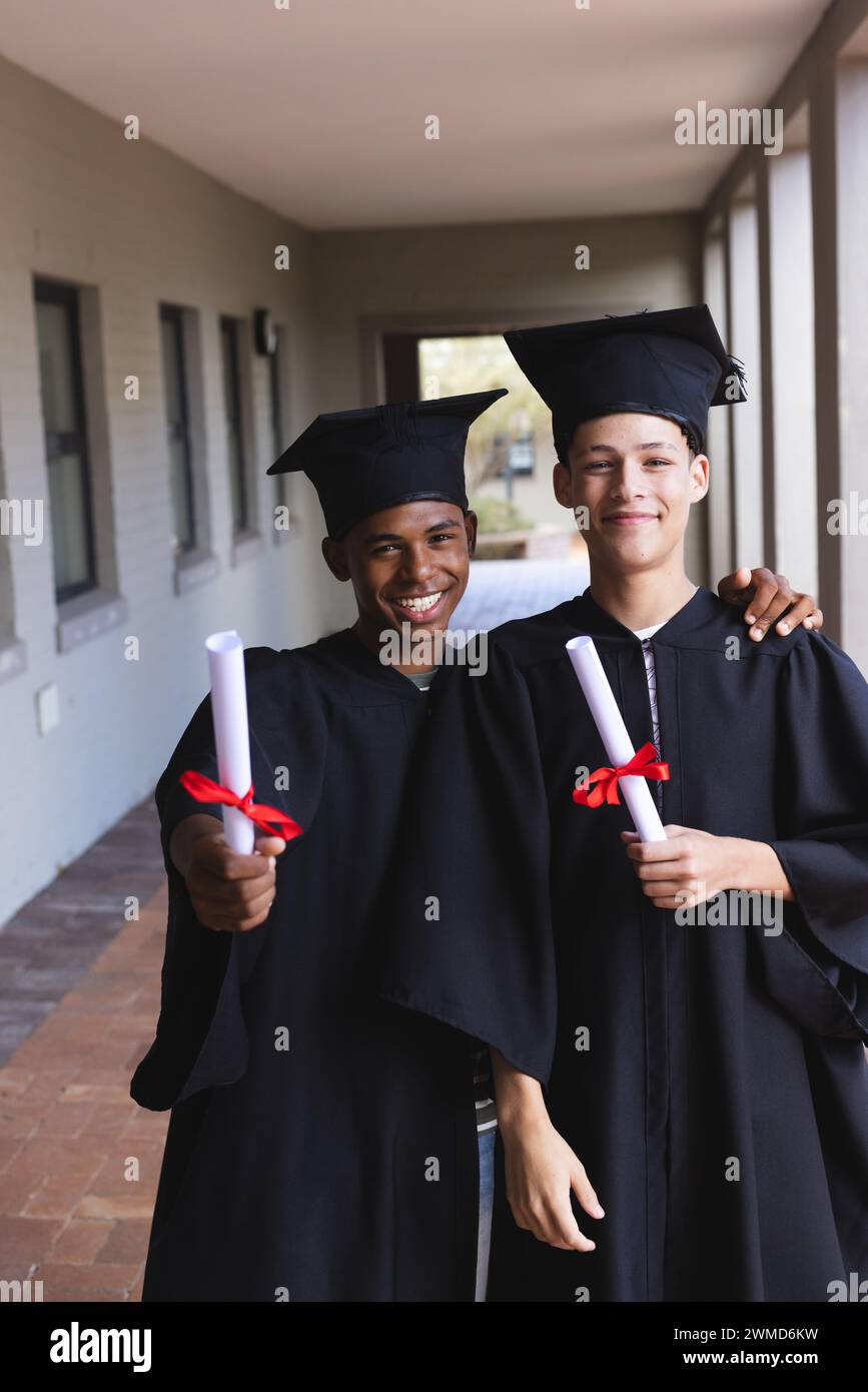 Zwei Teenager-Biracial-Jungs feiern den Abschluss im Freien Stockfoto