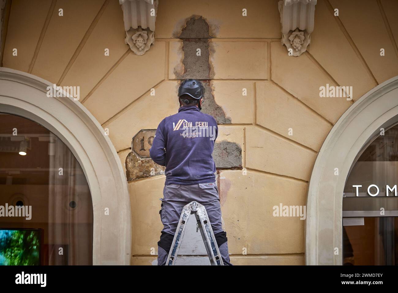 Ein Arbeiter restauriert eine Ladenfront in Rom, Italien. Stockfoto
