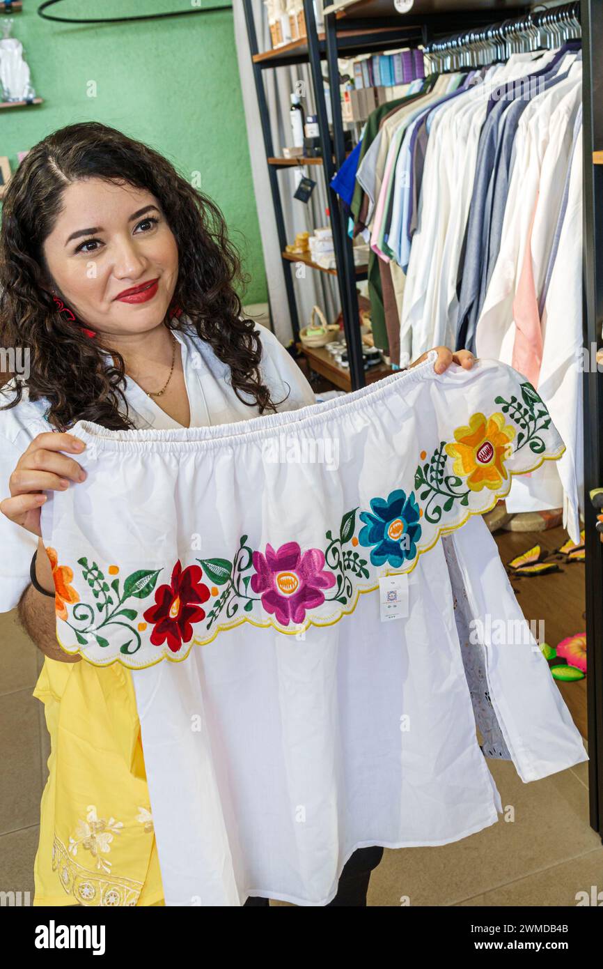Merida Mexico, Uxmal Souvenirverkäufer, weibliche Frauen, erwachsene Erwachsene, Bewohner, Manager Verkäufer, zeigt Frauen besticktes Kleid Oberteil, Stockfoto