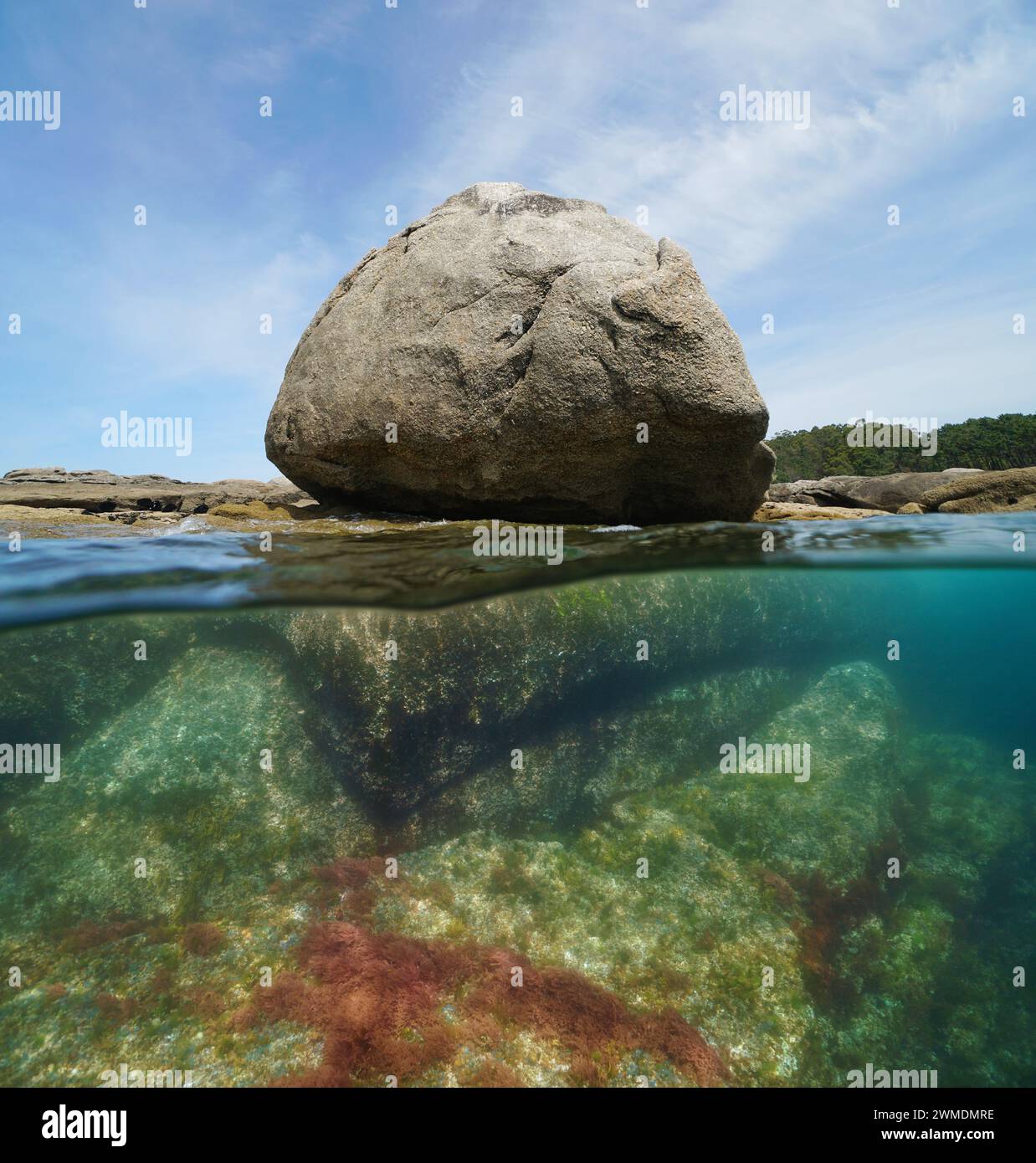 Granitfelsen am Meeresufer, geteilter Blick zur Hälfte über und unter der Wasseroberfläche, natürliche Szene, Atlantikküste in Spanien, Galicien, Rias Baixas Stockfoto