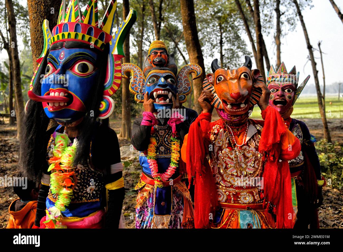 Maskierte Tänzer der Gomira-Tanztruppe sahen sich bei der Vorbereitung auf ihre Vorstellung in einem Dorf in der Nähe von Raiganj zugewandt. Gomira ist eine maskierte Tanzform. Das Wort „Gomira“ stammt von der umgangssprachlichen Form des Wortes „Gram-Chandi“ oder der weiblichen Gottheit, die die Schutzkraft des Dorfes ist. Der genaue Ursprung der Tanzform ist nicht nachvollziehbar und das Wissen ist im Laufe der Zeit verloren gegangen. Der Gomira-Tanz ist eine ländliche Tanzform, die hauptsächlich im Distrikt Dinajpur in Westbengalen praktiziert wird. Die Gomira-Tänze werden organisiert, um die Gottheit zu besänftigen, die „Guten Mächte“ einzulassen und die „bösen Mächte“ auszutreiben. Das ist normalerweise der Fall Stockfoto