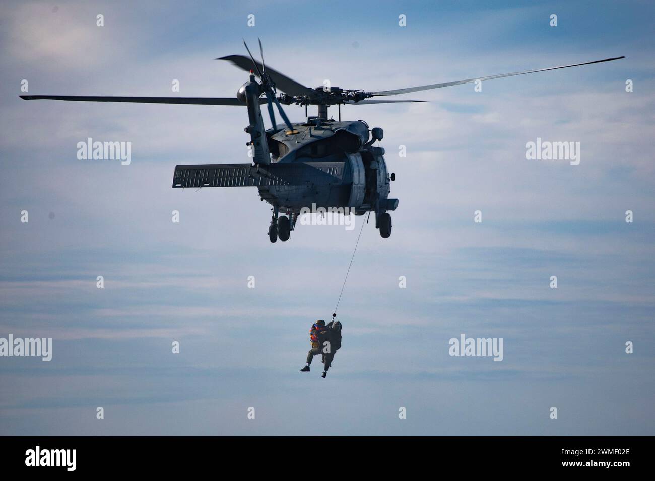 Ein MH-60S Seahawk, der der Helicopter Sea Combat Squadron 23 „Wildcards“ zugewiesen ist, hebt einen Luftrettungsschwimmer und einen Scheinastronauten aus einem Rettungsfloß, während er mit der USS San Diego (LPD 22) für den Lauftest 11 der NASA vom 23. Februar 2024 unterwegs ist. In Vorbereitung auf die bemannte Mission Artemis II der NASA, die vier Astronauten nach Orion jenseits des Mondes entsenden wird, werden die NASA und das Verteidigungsministerium eine Reihe von Tests durchführen, um die Prozesse, Verfahren und Hardware zu demonstrieren und zu bewerten, die bei der Bergung von bemannten Mondmissionen verwendet werden. Die U.S. Navy verfügt über viele einzigartige Fähigkeiten, die sie zu einer ide machen Stockfoto