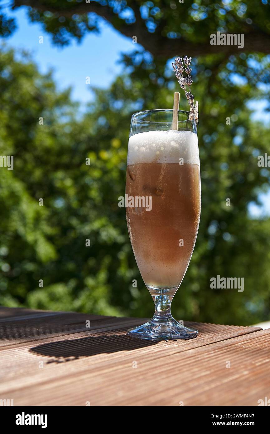 Smoothie oder kalter Kaffee auf grünem Hintergrund. Vorlage für die Werbung für Ihr Produkt. Vertikales Foto Stockfoto