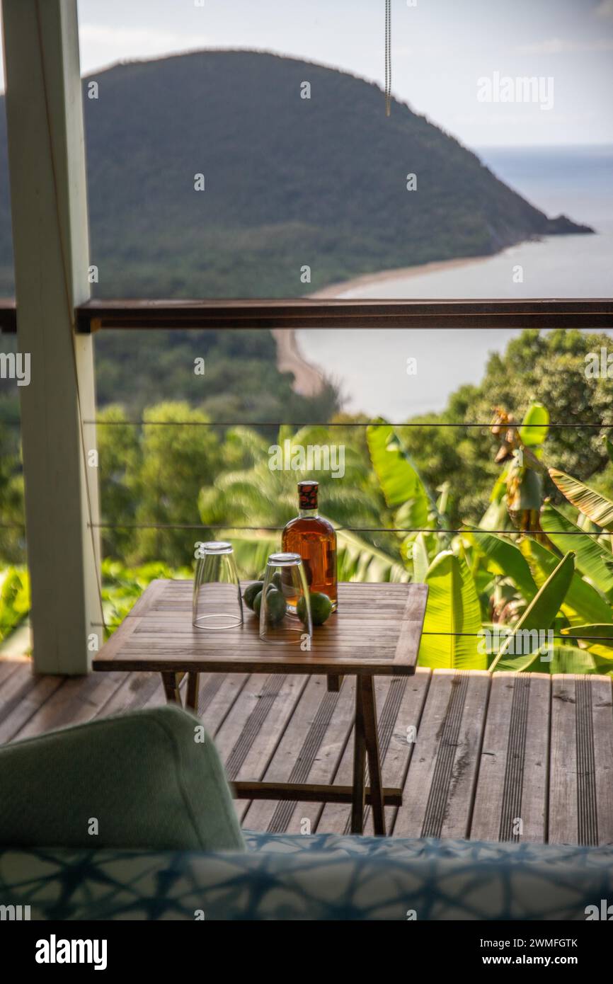 Rum Limetten und Gläser auf einem Tisch einer Terrasse im Vordergrund, im Hintergrund der Strand Grande Anse auf Basse Terre, Guadeloupe, die Franzosen Stockfoto