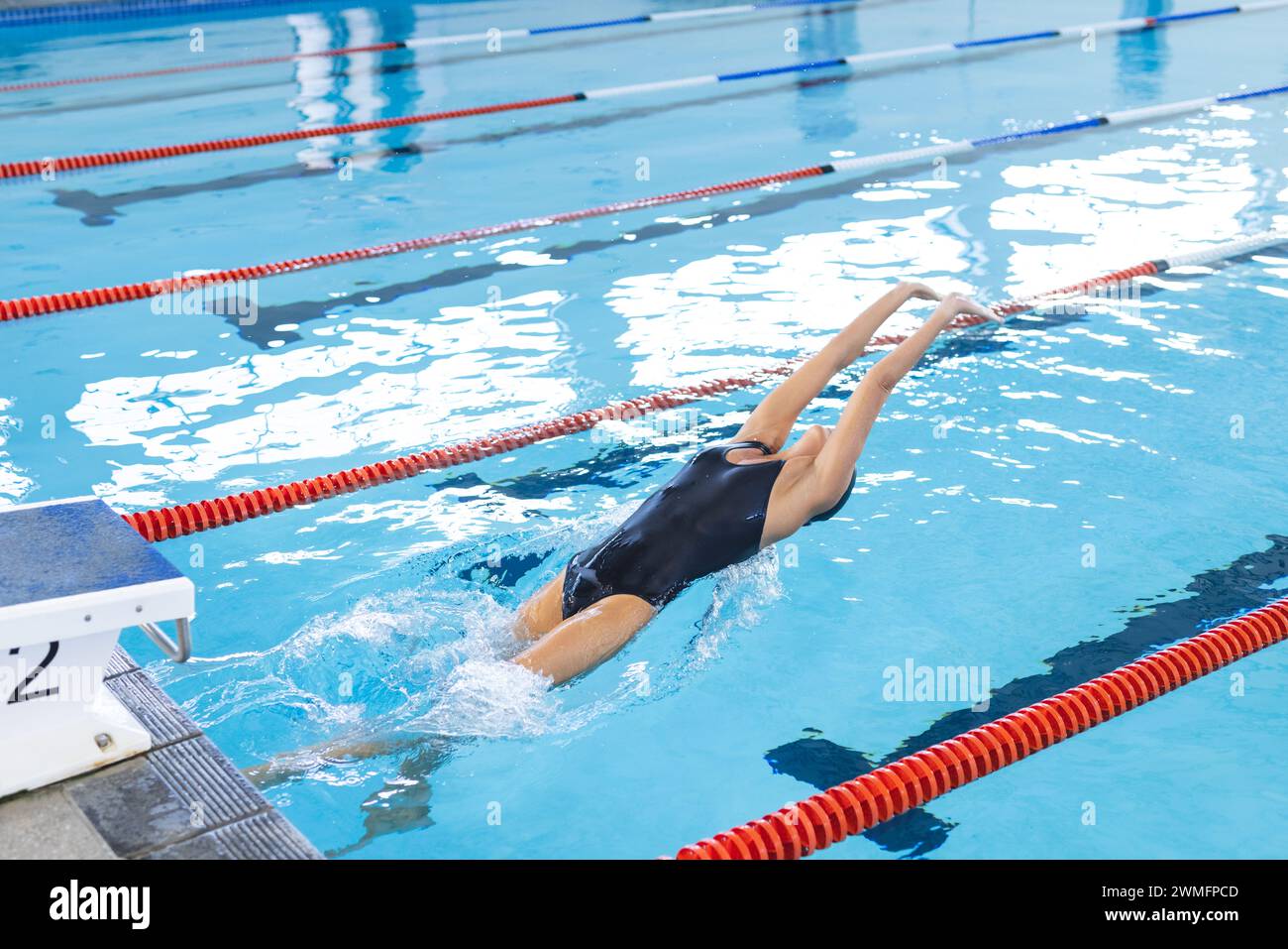 Der Schwimmer taucht bei einer Wettkampfveranstaltung in einen Pool mit Platz zum Kopieren Stockfoto