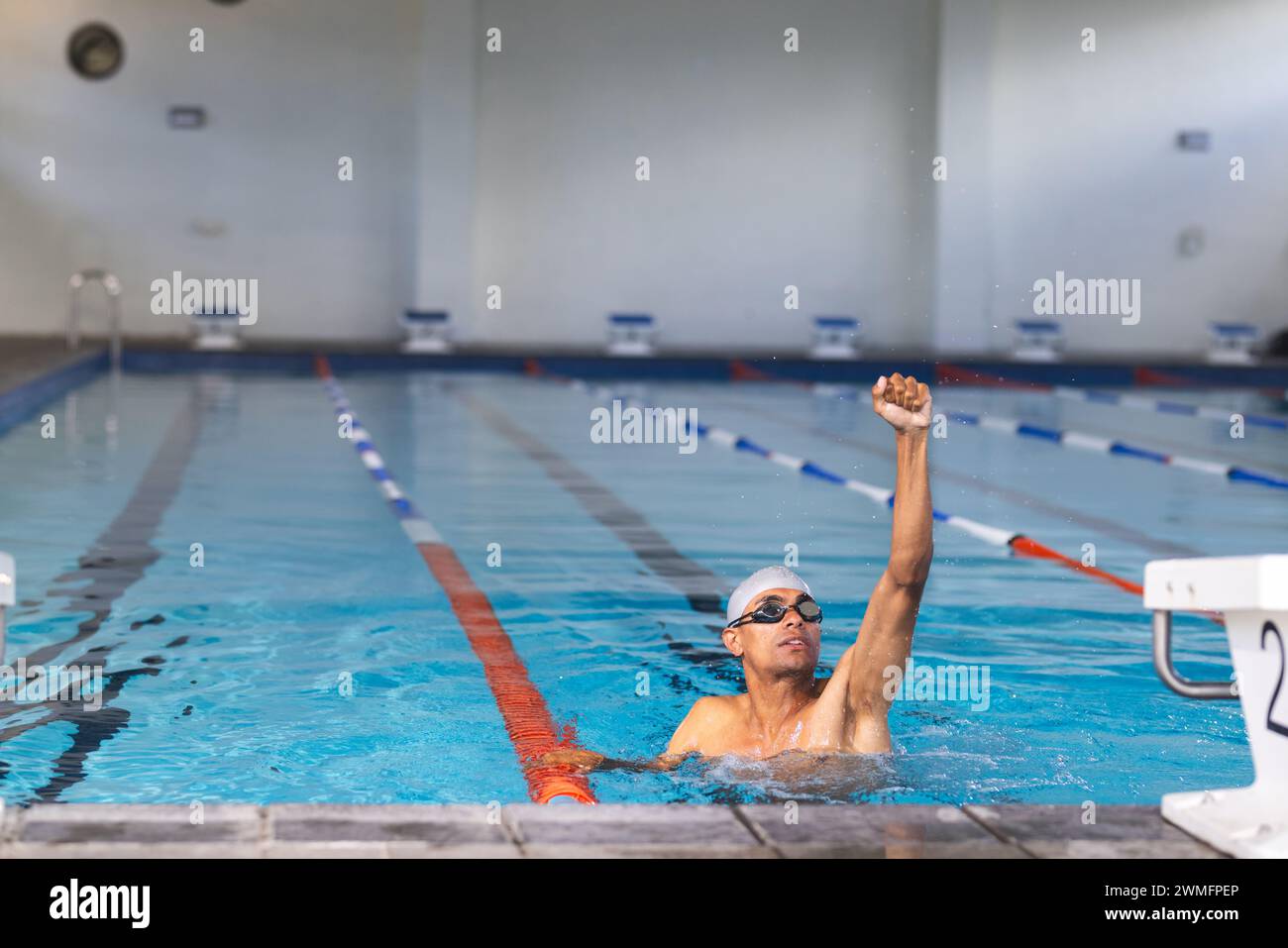 Ein Schwimmer erreicht das Ende des Pools in einer Inneneinrichtung Stockfoto