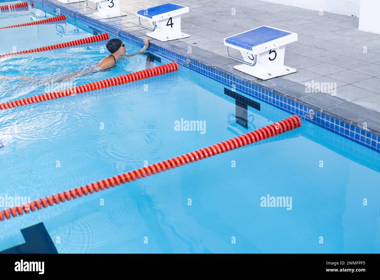 Der Schwimmer taucht bei einer Wettkampfveranstaltung in einen Pool mit Platz zum Kopieren Stockfoto