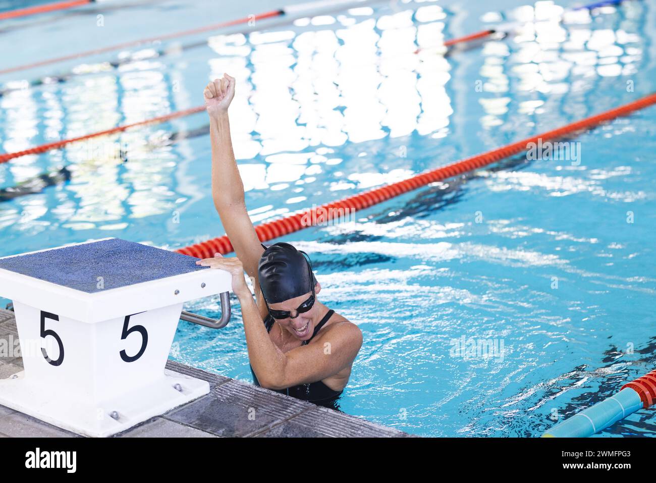 Ein Schwimmer feiert den Sieg am Pool, mit Kopierraum Stockfoto