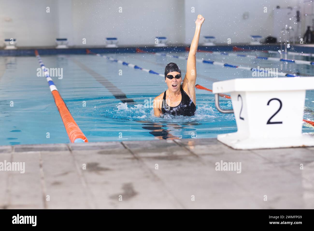 Die weiße Schwimmerin feiert einen Schwimmsieg am Pool Stockfoto