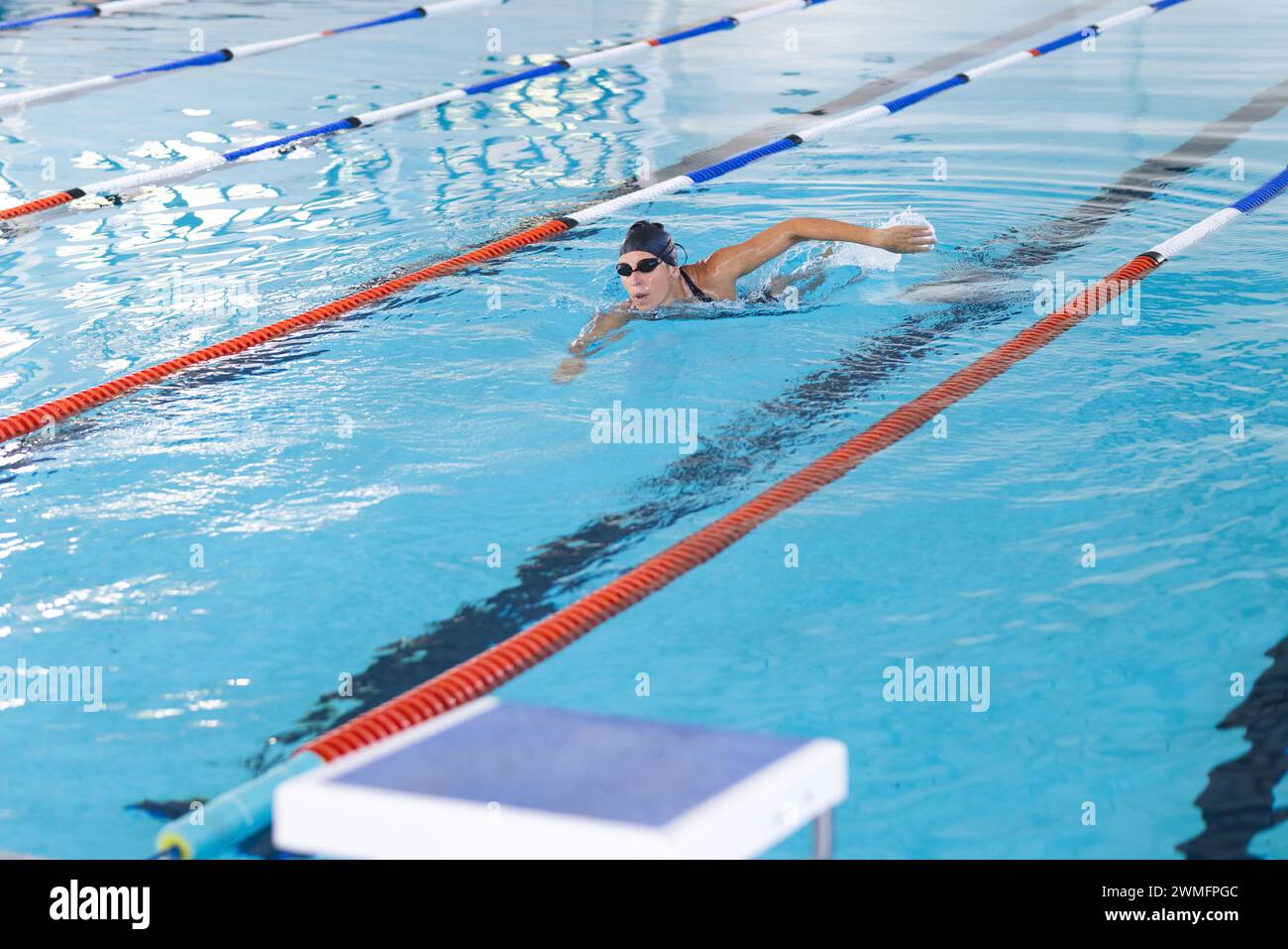 Eine weiße Sportlerin schwimmt in einem Pool und zeigt ihre sportliche Form Stockfoto