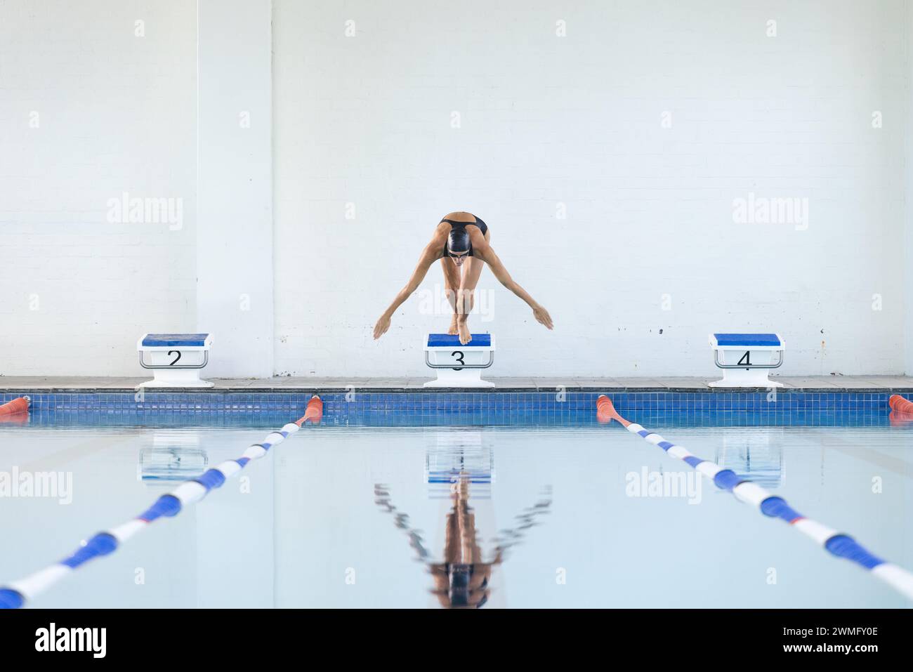 Der Sportler taucht in ein Schwimmbad in einer Sportanlage ein Stockfoto