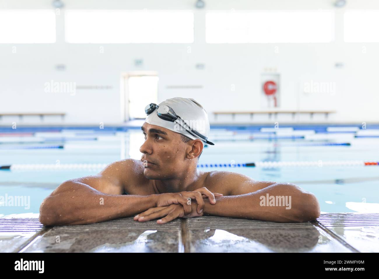 Junge männliche Sportlerinnen und Sportlerinnen ruhen am Pool, mit Kopierraum Stockfoto