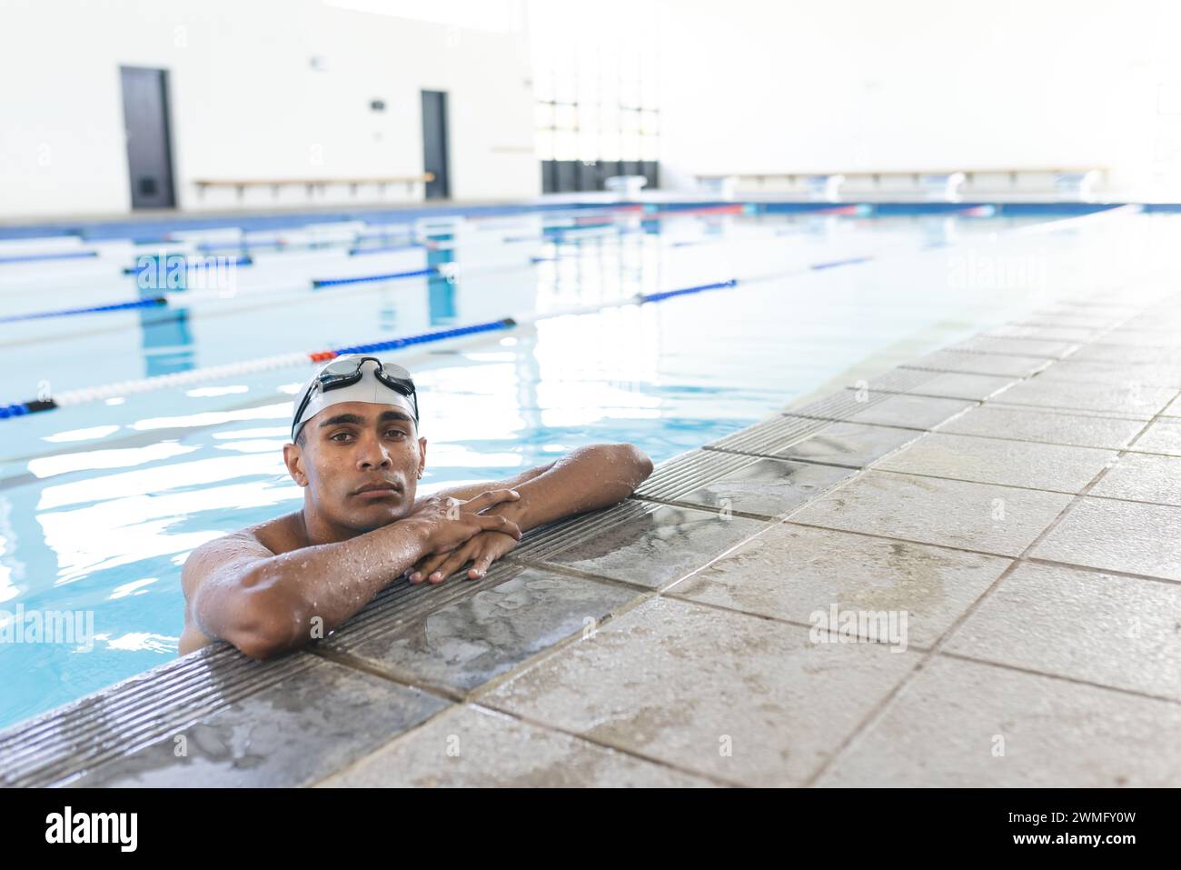 Junge männliche Sportlerinnen und Sportler ruhen sich nach dem Schwimmen am Pool aus, mit Kopierraum Stockfoto