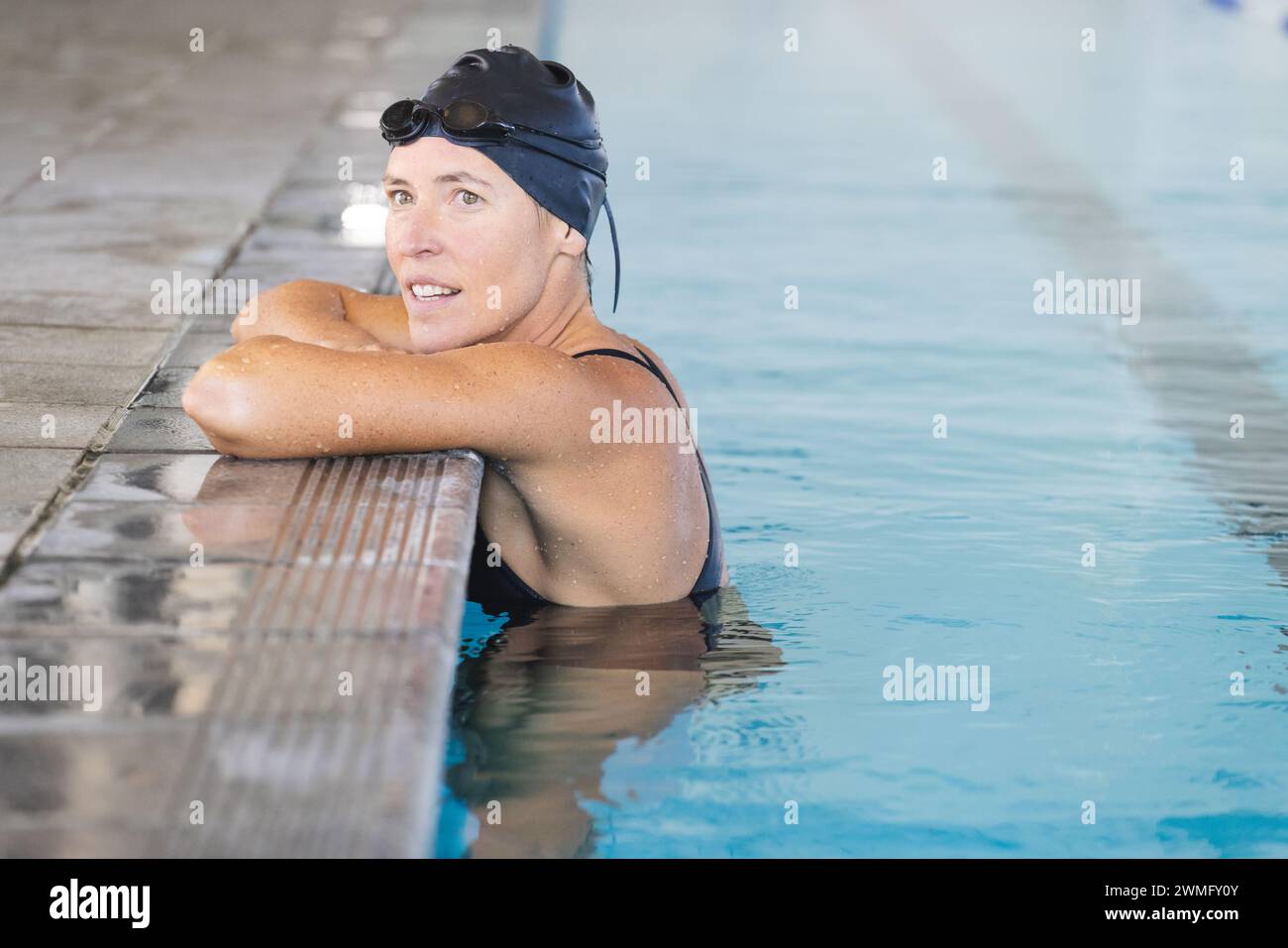 Nach dem Schwimmen ruht sich die weibliche weibliche Sportlerin am Pool aus Stockfoto