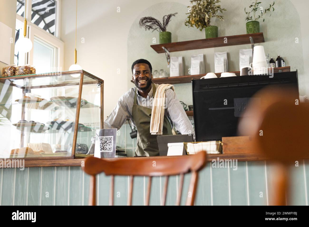 Ein afroamerikanischer Geschäftsmann lächelt hinter dem Café Stockfoto