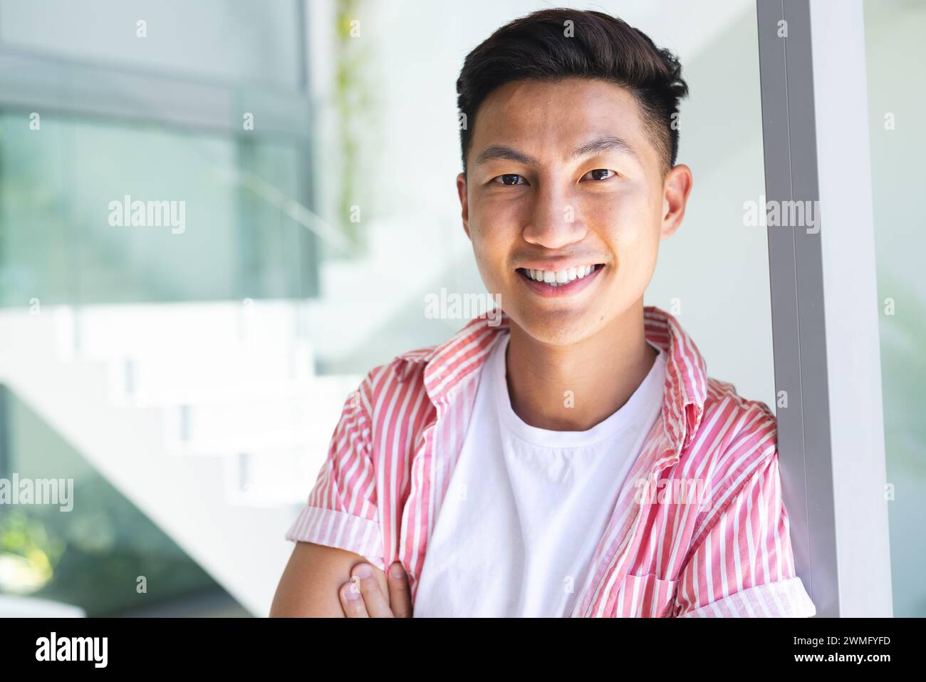 Ein junger asiatischer Mann lächelt hell, mit Kopierraum Stockfoto