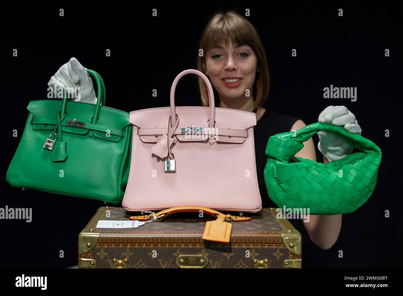 Bonhams, Knightsbridge, London, Großbritannien. Februar 2024. Bonhams Knightsbridge beherbergt die ersten Designer Handtaschen und Mode Sale von 2024. Der Live-Verkauf findet am 28. Februar statt. Zu den Höhepunkten gehören (Mitte): Hermès: Rose Sakura Swift Leather Birkin 25, 2023 (inklusive Zubehör), geschätzte £18.000-22.000; (links) Hermès: Bambou Swift Leather Birkin 25, geschätzte £12.000-18.000; (rechts) Bottega Veneta: Papageien Green Lammfell Mini Jodie, geschätzte £700-900. Quelle: Malcolm Park/Alamy Live News Stockfoto